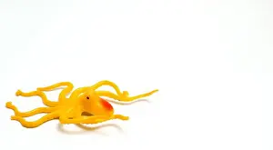 Plush Prints: A Yellow Octopus Shaped Children's Toy With Isolated White Background And With Composition Leaving Space On The