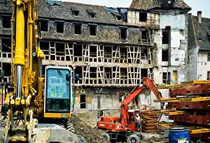 Alsatian Prints: Yellow and red diggers on ancient half-timbered house renovation site