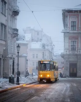 Yellow tram on Market central square in winter Lviv city, Ukraine, Europe. Morning cityscape