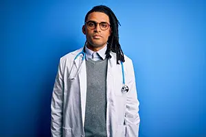 Young african american doctor man with dreadlocks wearing stethoscope and glasses with serious expression on face