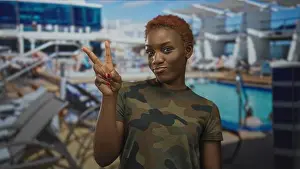 Military Uniform Prints: Young african american woman wears camouflage shirt and makes peace sign with hand on boat deck; peace