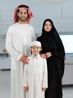 Ramadan Prints: young arabian muslim family wearing traditional clothes at their modern house spending time together during Ramadan