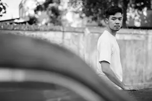 Stubble Prints: Young Asian man with rusty old car in the streets outdoors