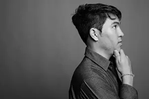 Afghan Prints: Young Asian man wearing button down shirt against gray background