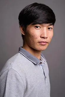 Bangs Prints: Young Asian man wearing gray polo shirt against gray background