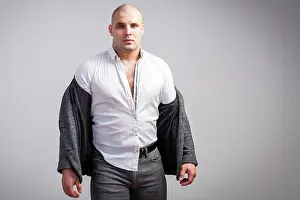 Desperate Prints: A young bald man in an unbuttoned gray suit and white shirt is disheveled and upset on a white isolated background