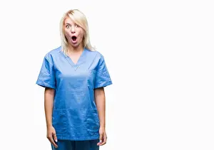Panic Prints: Young beautiful blonde nurse doctor woman over isolated background afraid and shocked with surprise expression