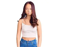 Amusing Prints: Young beautiful chinese girl wearing casual clothes puffing cheeks with funny face
