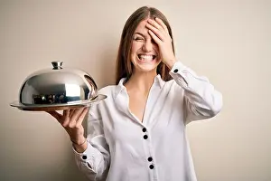 Redhead Prints: Young beautiful redhead woman holding waitress tray over isolated white background stressed with hand on head