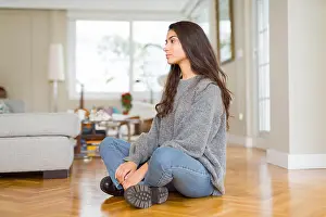 Lateral Prints: Young beautiful woman sitting on the floor at home looking to side