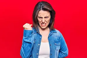 Aggressive Prints: Young beautiful woman wearing casual clothes angry and mad raising fist frustrated