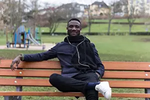 Real Life Prints: Young Black Man Leaning Back on Park Bench Confidently