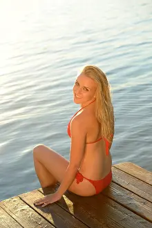 Women Only Prints: Young blond woman in bikini on a jetty at a lake, Styria, Austria