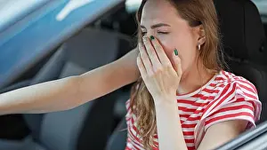 Exhausted Prints: Young blonde woman tired driving car yawning at street