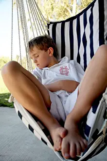Snooze Prints: young boy asleep outside in rope chair after school