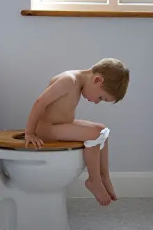 Young boy child on the loo toilet bog lavatory WC in a house CJWH