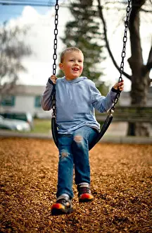 Differential Prints: Young boy playing on a swing in a park