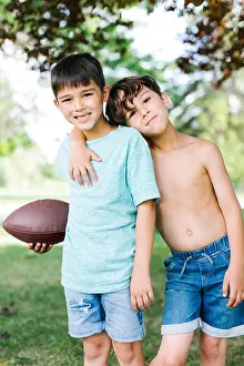 Weekend Activities Prints: Young boys (6-7, 8-9) with american football ball