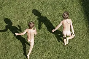 Boys Prints: Two young boys or children from above running away in a suburban garden in summer London England UK Naked nude or bare
