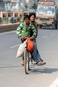 Road Safety Prints: Two young boys riding on a bicycle on the main road in Agra, Uttar Pradesh.India
