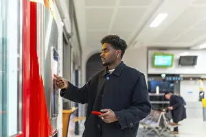 Business Attire Prints: Young businessman standing at a train station