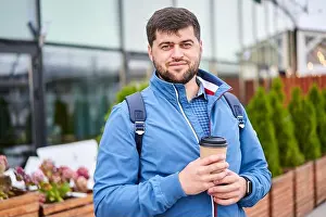 Office Worker Prints: Young businessman with takeaway paper cup of coffee