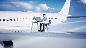 Airliner Prints: Young busy businessman working on the flying airplane