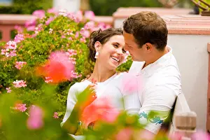 Cuddling Prints: A young Caucasian couple cuddling in garden