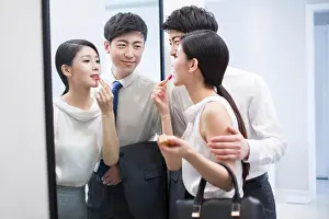 Toothy Smile Prints: Young Chinese couple looking into a mirror before going to work