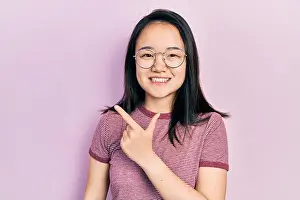 Presenting Prints: Young chinese girl wearing casual clothes and glasses cheerful with a smile of face pointing with hand