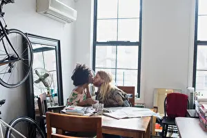 Curly Hair Prints: A young couple kissing at a dining table