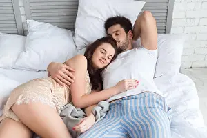 Pajamas Prints: young couple in pajamas sleeping in bed together