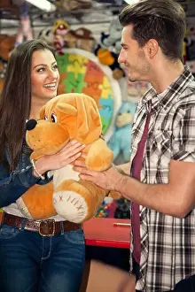 Flirting Prints: Young couple playing shooting games while visiting an amusement park