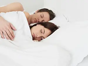 Tiredness Prints: Young couple sleeping in bed man's arm around woman