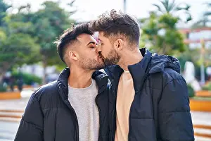 Young couple standing together kissing at park