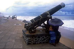 Beachfront Prints: Young couple under umbrella by cannon, taken in 2004, Galle Face Green, Colombo, Sri Lanka