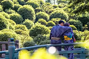 Cuddling Prints: A young couple wearing kimonos cuddling on a bridge