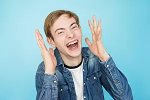 Shout Prints: young emotional funny male teenager in denim shirt on blue background
