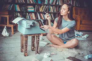 Concentrated Prints: Young female writer in library indoors working smoking cigarette typing writing romantic novel serious