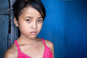 Developing Country Prints: Young Filipina girl 8 years old with sad and somber expression over blue