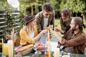 Toasting Prints: Young friends dining at backyard of the country house in nature