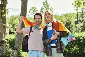 Casual Attire Prints: Two young friends pose for a photo outdoors, holding a rainbow pride flag