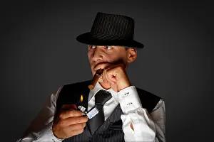 Mafia Prints: young gangster with hat smoking cigar, studio shot
