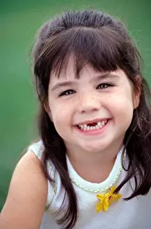Toothy Smile Prints: Young girl with brown hair smile missing her two front teeth
