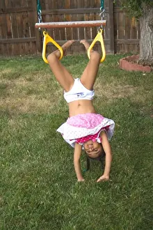 Young girl child playing in garden hanging upside down, MR#543