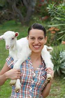 Adult Only Prints: Young girl with goat on shoulders looking into camera happy