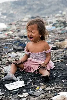 Hurt Prints: A young girl living in poverty cries out in pain at the toxic and polluted Stung Meanchey landfill in Phnom Penh