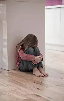Young girl sat unhappy on the floor