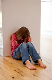 Young girl sat unhappy on the floor