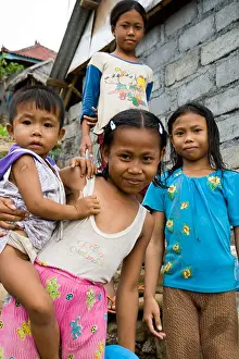 Infant Prints: Young girls greet visitors in the small coastal town of Amed Bali Indonesia